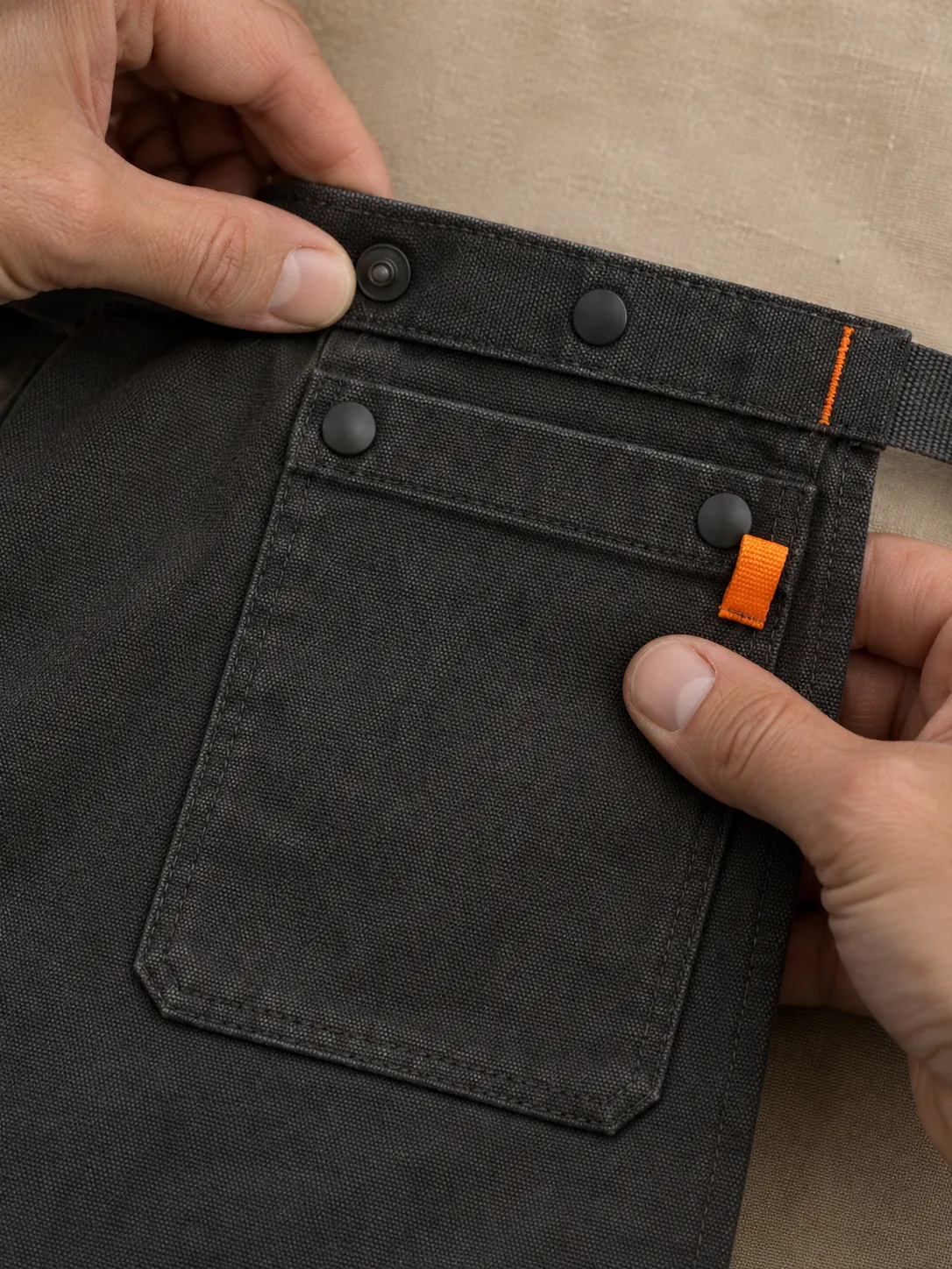 Bistro Long Waist Apron, close-up of the snap rail and pull tab